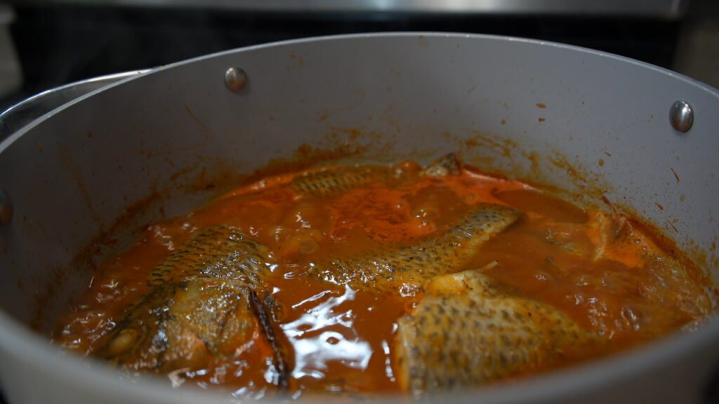 pepper soup with tilapia fish and spices cooking on the stove