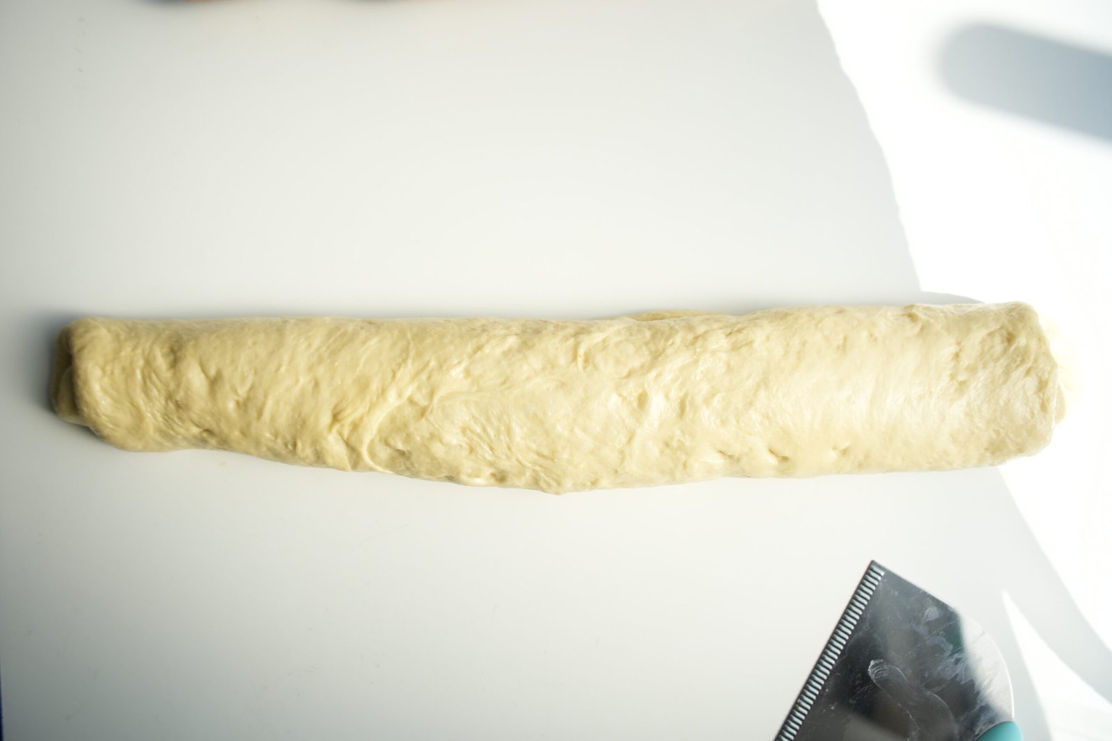 dough rolled into a log after butter has been spread over it