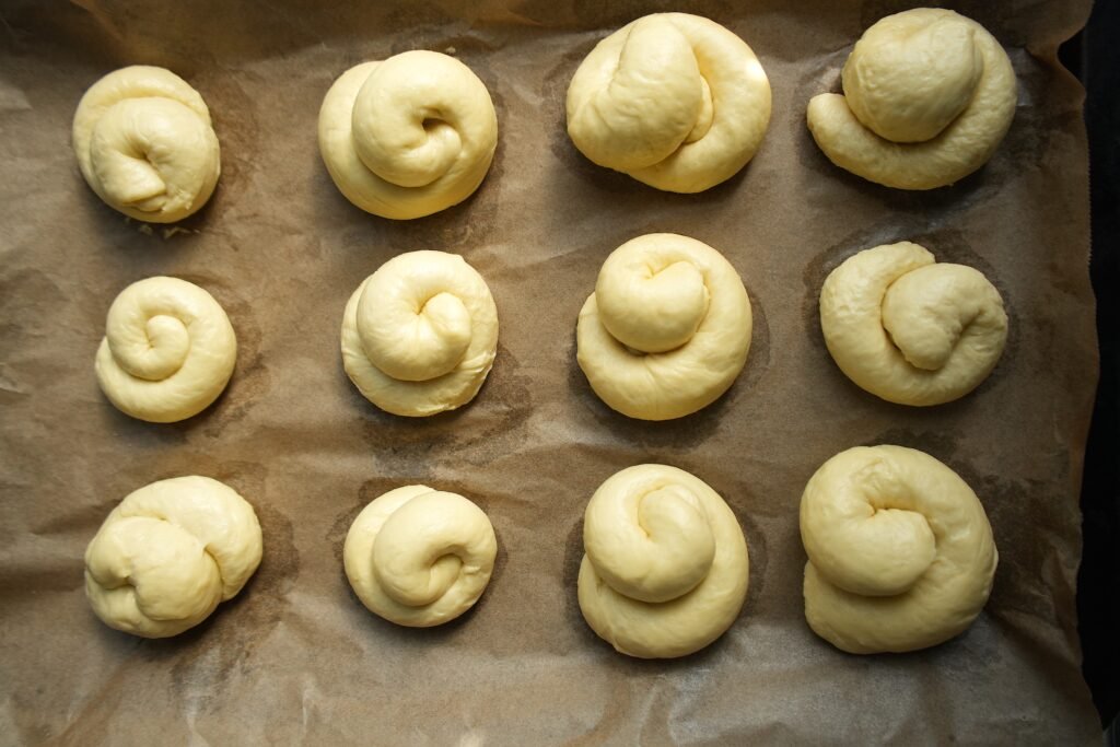 ensaimadas laid out on lined baking sheet