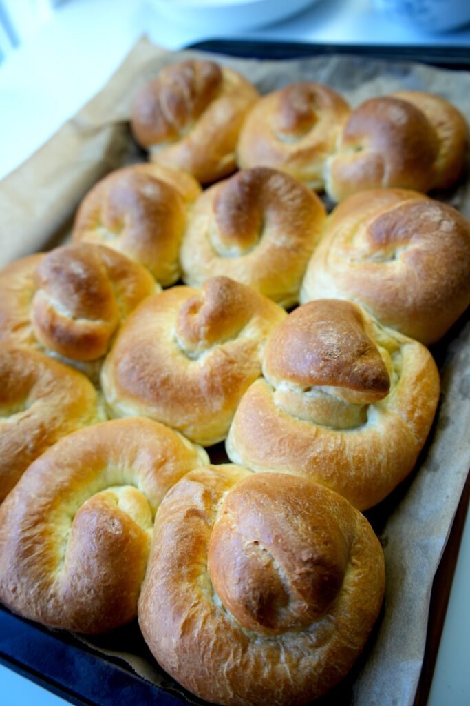 baked ensaimadas on a lined baking sheet