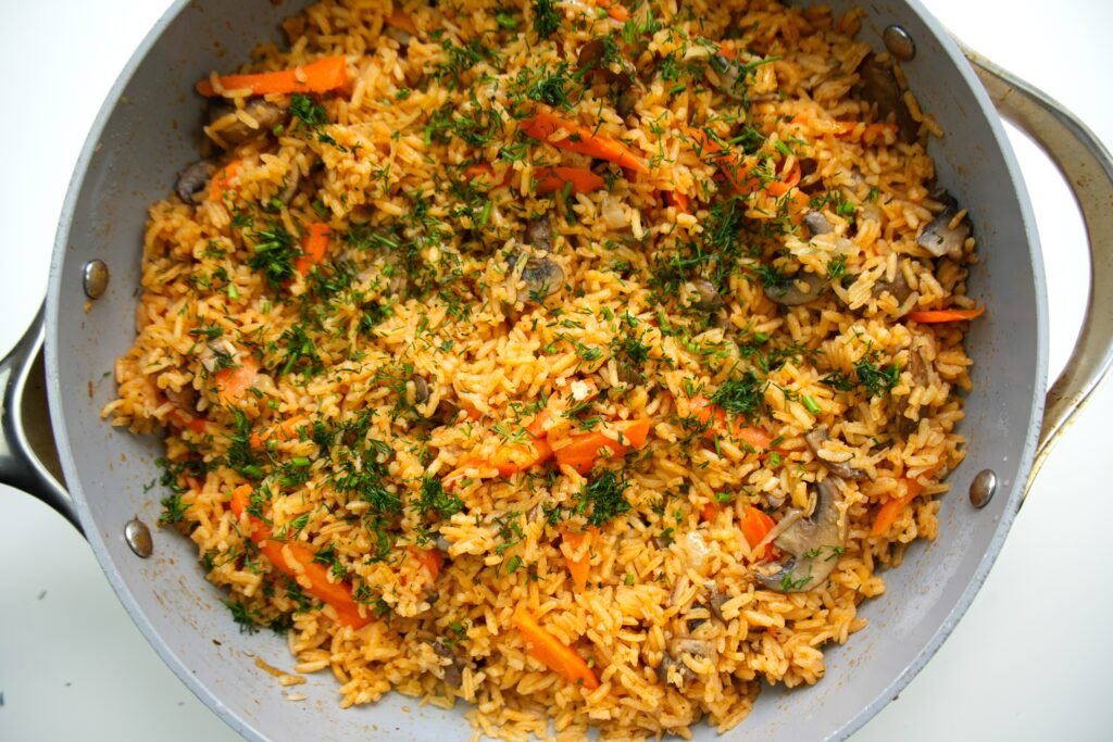 a pan of mushroom rice garnished with fresh dill