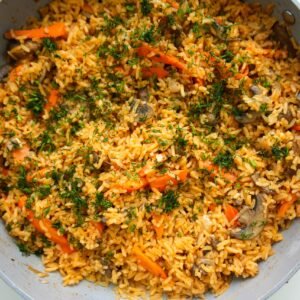 a pan of mushroom rice garnished with fresh dill
